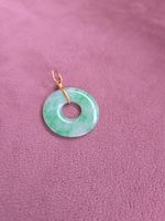 Jade pendant: One hand polished natural color jadeite donut set in 18K gold.