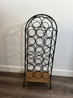 Ornate iron high capacity Tall wine rack holds 20 bottles with wicker base shelf
