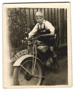 Photograph of a motorcycle, blond boy on a motorcycle with license plate...