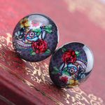 A PAIR OF SKULL FLOWER THEMED STUD EARRINGS. NEW.