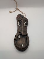 handcrafted wooden mask featuring a dark brown finish with rustic detailing