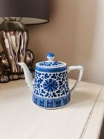 vintage porcelain China teapot featuring a blue and white floral design