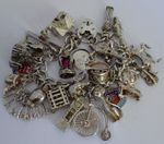 Vintage heavy solid silver charm bracelet &many curious silver charms inc moving
