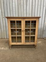 An Art Nouveau stripped pine and stained glass cabinet, on later feet c.1910