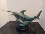 Bronze sculpture of a marlin with a green patina finish mounted on a round base