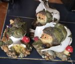 hedgehog figurines feature a detailed, hedgehogs resting amongst berries