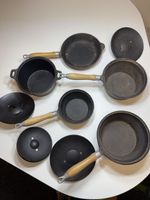 Vintage cast iron cookware featuring wooden handles