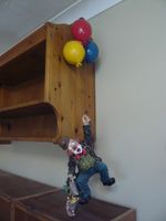 Set of three ceramic clowns, one broken coat-tail. Small crack in umbrella.