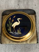 vintage compact black enamel lid with a heron bird design and gold-tone casing.