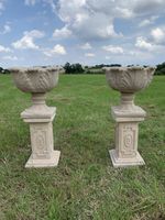 A Pair Of Cast stone plinths and tulip planters