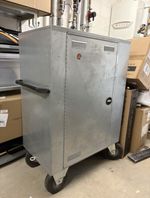 Large metal mobile tack locker with wheels, saddle rack and a lockable door.