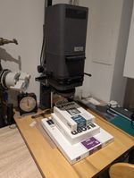 Enlarger + lens + contrast + trays + light + left overpaper + leftover chemicals