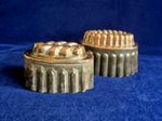 Two antique tin and copper jelly moulds.