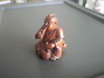 Hand Carved wood netsuke man sits to smoke with pipe and basket boxwood figure