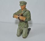 LINEOL  GERMAN OFFICER KNEELING DOWN CUTTING BREAD.