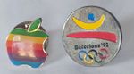 A pair of bin badges, Rainbow Apple and Barcelone Olympics 1992