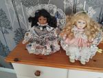 2 Leonardo Porcelain Dolls Sitting In Wicker Chairs