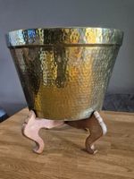 ANTIQUE HAMMERED BRASS PLANTER ON CARVED WOODEN LEGS. MARKED HONG KONG TO BASE.
