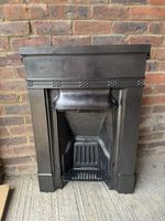 A RESTORED RECLAIMED EDWARDIAN CAST IRON BEDROOM FIREPLACE