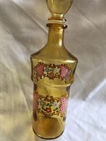 Orange glass bottle, 11" high, floral pattern on front
