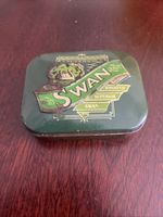 This is a vintage or classic Swan 1 oz/2 oz green and gold metal tobacco tin