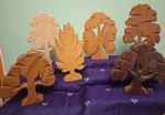 Six rustic carved wooden trees with corresponding carved leaves leaves.