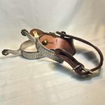  pair of ornate Western style spurs with leather straps.