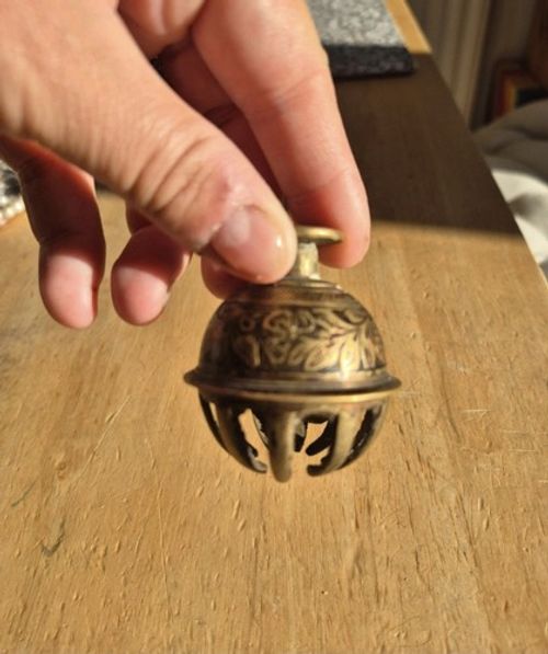 Vintage Indian brass elephant claw bell featuring hand-etched floral patterns